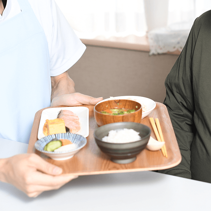 利用者に食事を提供する世話人のイメージ画像